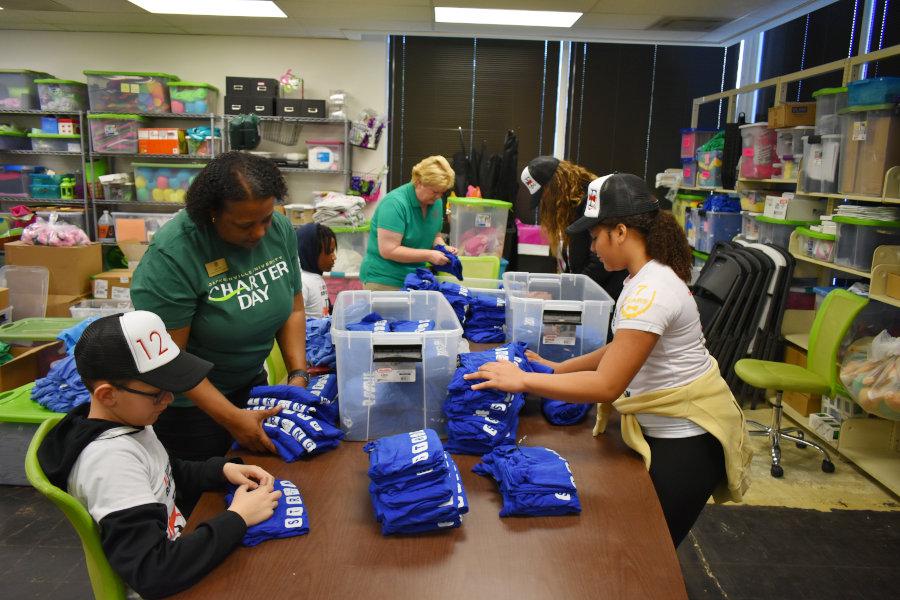 Charter Day Volunteers sorting clothing items at a Community Partner locations